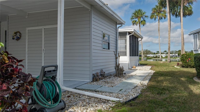 view of side of property with a yard and a sunroom