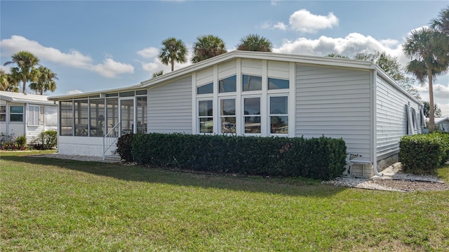 view of side of property with a sunroom and a yard