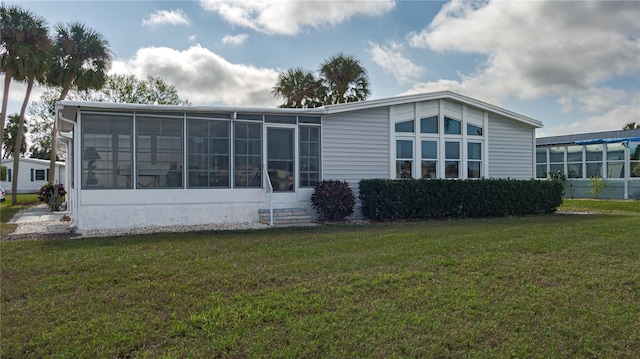 back of house with a yard and a sunroom