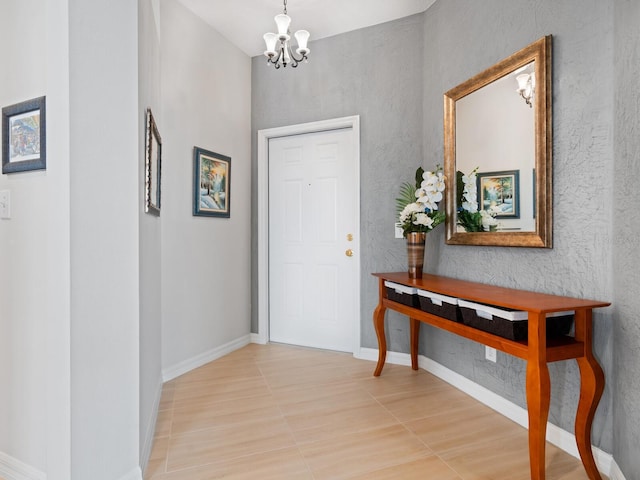 foyer entrance featuring baseboards and an inviting chandelier