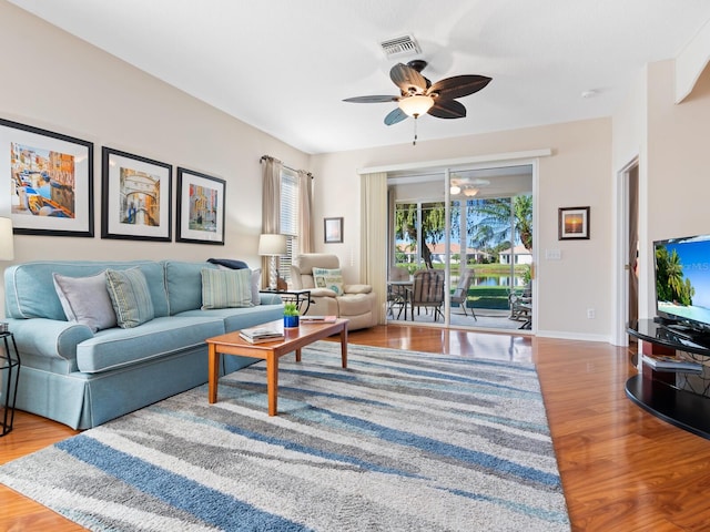 living room with a ceiling fan, baseboards, visible vents, and wood finished floors