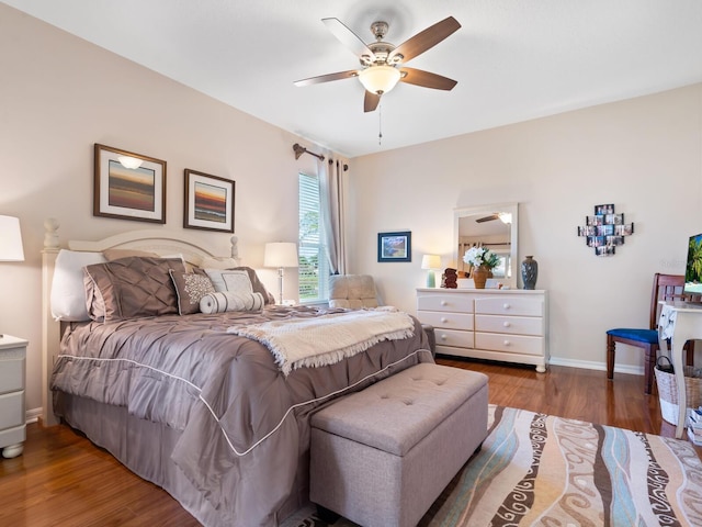 bedroom with a ceiling fan, baseboards, and wood finished floors