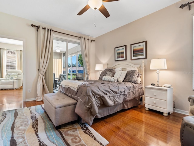 bedroom featuring access to outside, baseboards, ceiling fan, and wood finished floors