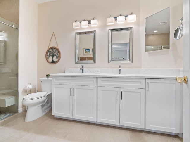 bathroom with toilet, double vanity, a tile shower, and a sink