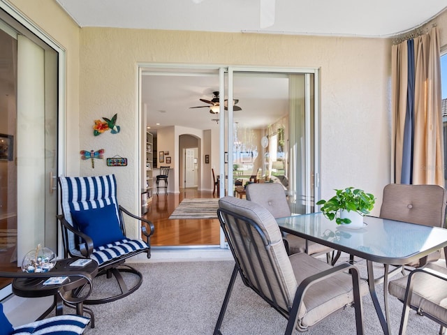 sunroom / solarium featuring arched walkways and a ceiling fan