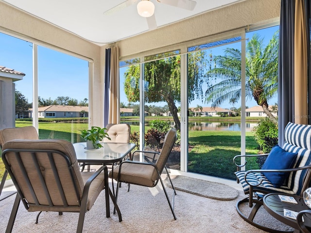 sunroom featuring a water view and ceiling fan