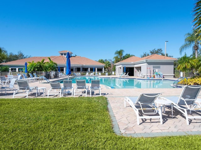 pool featuring fence, a lawn, and a patio