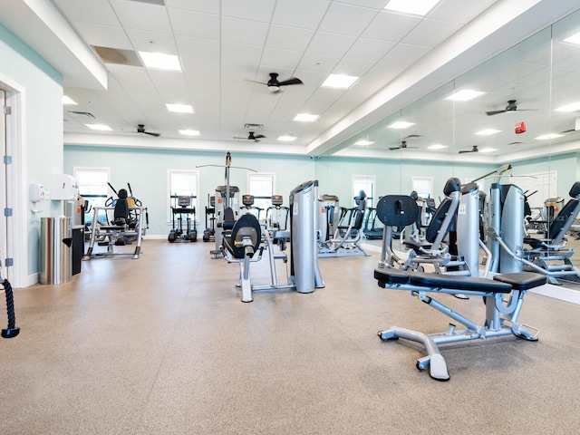 workout area featuring a wealth of natural light, a drop ceiling, ceiling fan, and baseboards