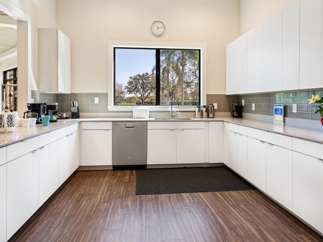 kitchen with a sink, tasteful backsplash, light countertops, and stainless steel dishwasher