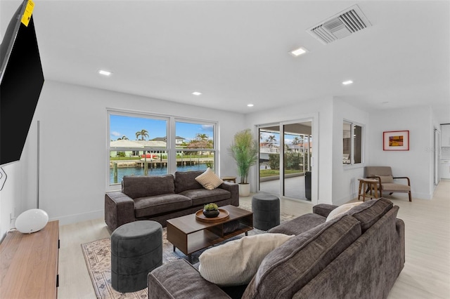 living room featuring light wood-type flooring and a water view