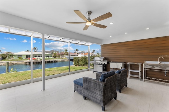 sunroom with a water view and ceiling fan