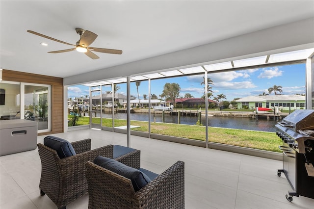 sunroom with a water view and ceiling fan