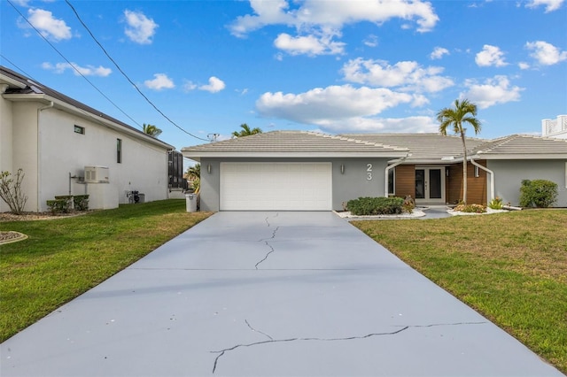 ranch-style house featuring a garage and a front lawn