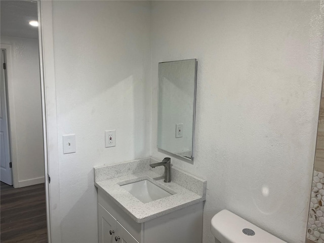 bathroom with vanity, wood-type flooring, and toilet