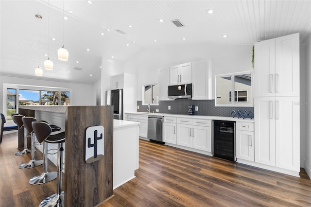 kitchen featuring wine cooler, white cabinetry, pendant lighting, and appliances with stainless steel finishes