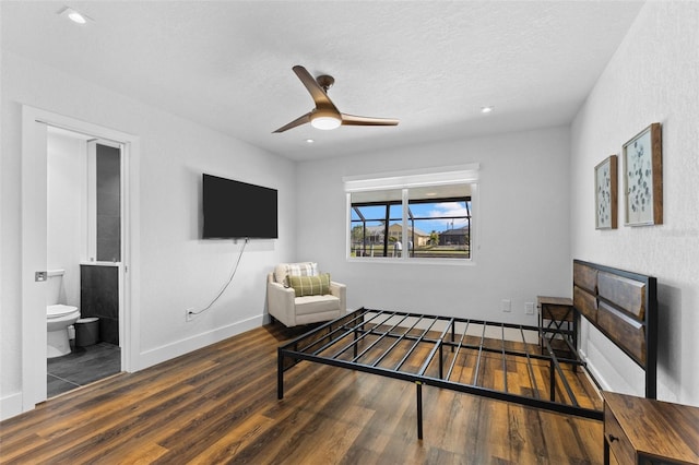 bedroom featuring dark hardwood / wood-style floors, a textured ceiling, and ensuite bath