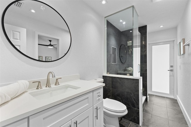 bathroom featuring tile patterned floors, vanity, toilet, and a shower with shower door