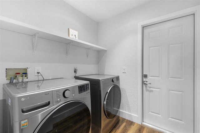 laundry area with wood-type flooring and washing machine and clothes dryer