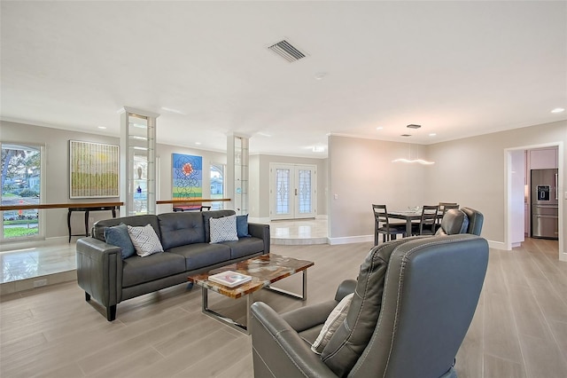 living area featuring light wood-style floors, french doors, visible vents, and baseboards