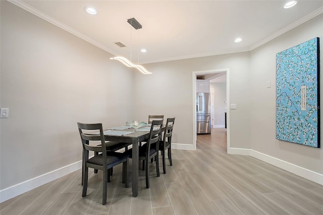 dining room featuring ornamental molding, recessed lighting, light wood-style floors, and baseboards