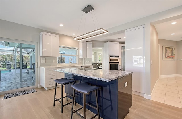 kitchen with a center island, decorative backsplash, white cabinets, a sink, and modern cabinets