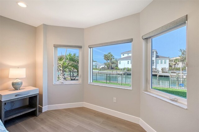 bedroom with a residential view, baseboards, and wood finished floors