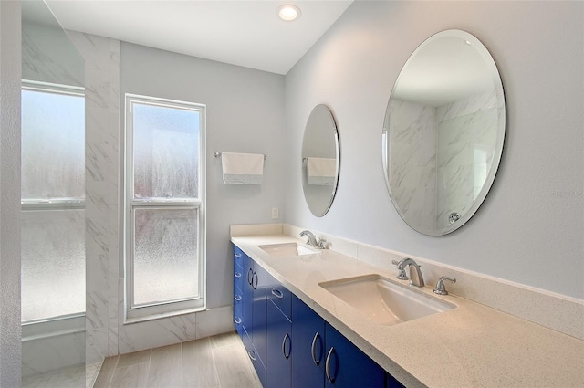 full bathroom featuring wood finished floors, a sink, and double vanity