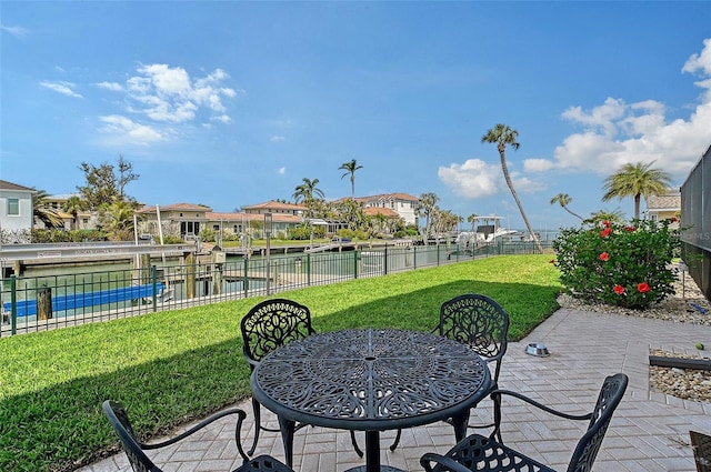 view of patio / terrace featuring a residential view, a water view, and fence