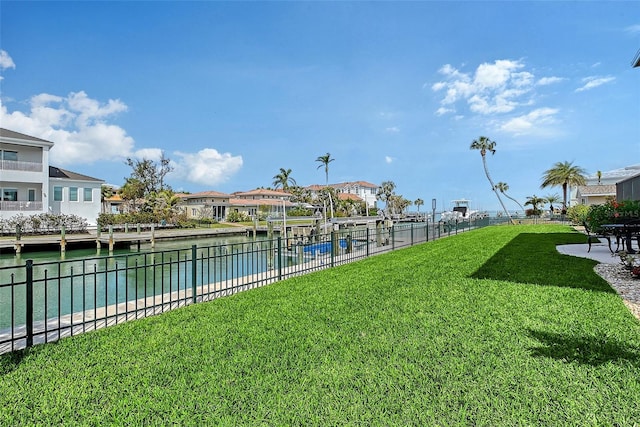 view of pool featuring a residential view, a water view, a yard, and fence