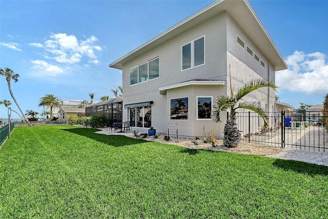 rear view of house with a yard, a patio, fence, and stucco siding