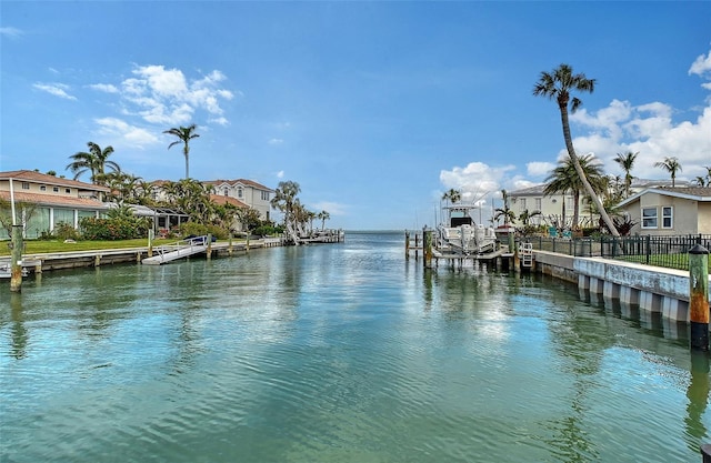 dock area with a residential view, a water view, and fence