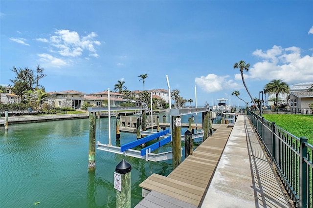 dock area with a residential view, a water view, and boat lift