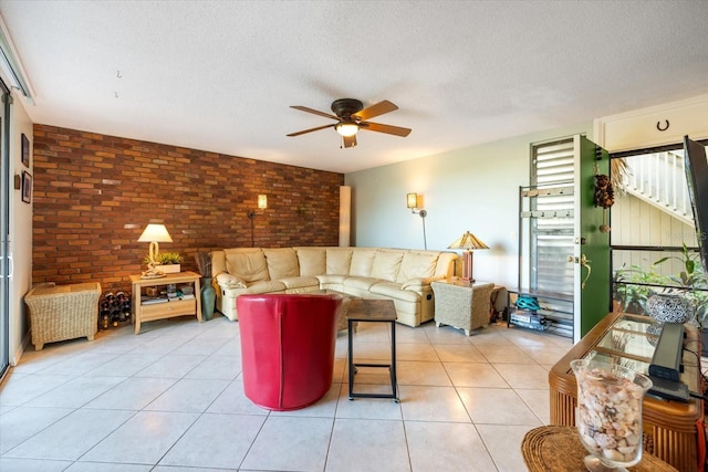 living room featuring light tile patterned flooring, brick wall, and a textured ceiling