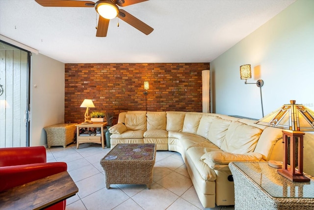 tiled living room featuring ceiling fan and brick wall