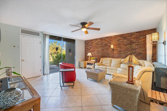 tiled living room featuring floor to ceiling windows, brick wall, a textured ceiling, and ceiling fan