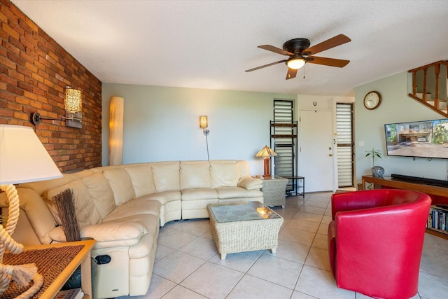 tiled living room featuring brick wall, a textured ceiling, and ceiling fan