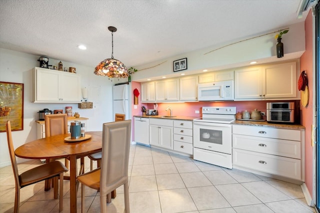 kitchen featuring light tile patterned floors, white appliances, white cabinetry, a textured ceiling, and decorative light fixtures