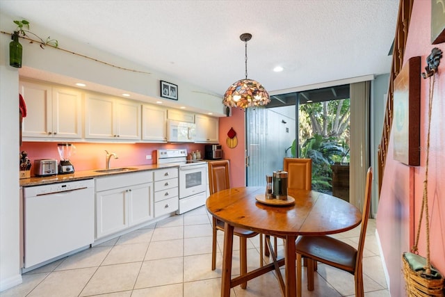 kitchen featuring decorative light fixtures, white cabinetry, sink, white appliances, and a textured ceiling