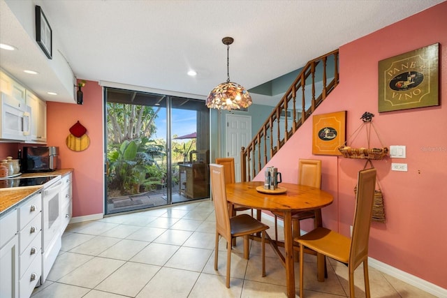 dining room with light tile patterned floors, expansive windows, and a textured ceiling