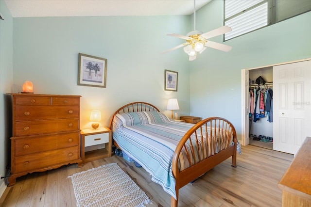 bedroom featuring ceiling fan, high vaulted ceiling, a closet, and light wood-type flooring