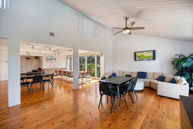 dining space featuring ceiling fan, high vaulted ceiling, and light wood-type flooring