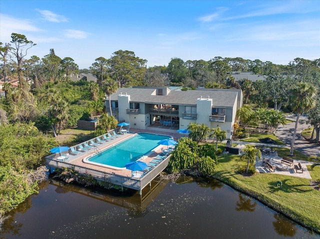 rear view of property featuring a yard, a patio area, and a water view