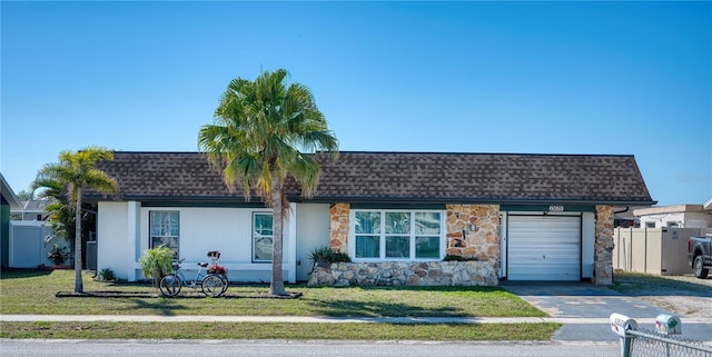 single story home with a garage and a front lawn