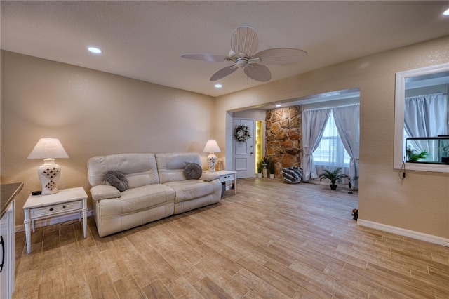 living room featuring ceiling fan and light hardwood / wood-style flooring