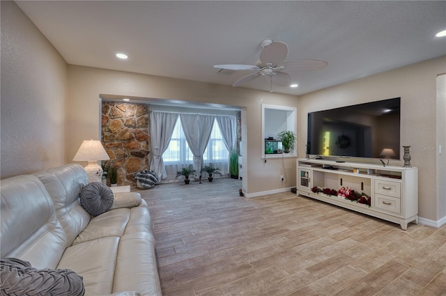 living room with ceiling fan and light wood-type flooring