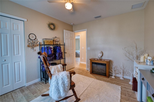 sitting room with ceiling fan and light hardwood / wood-style flooring