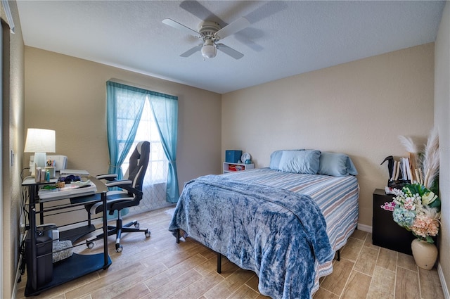 bedroom featuring ceiling fan, wood-type flooring, and a textured ceiling