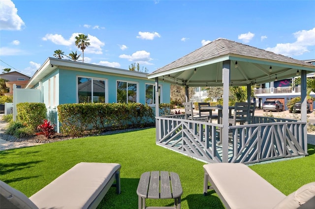 rear view of house with a yard and a gazebo