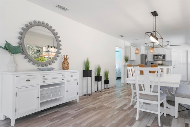 dining area featuring visible vents and light wood-style flooring