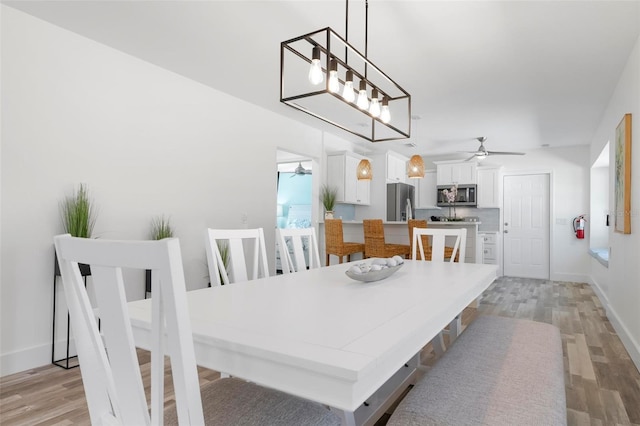 dining area with ceiling fan and light hardwood / wood-style flooring